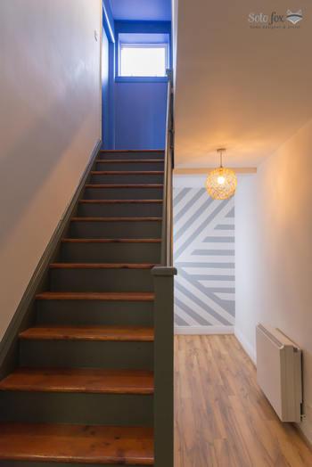 Stair case painted in sage green and part of the hallway