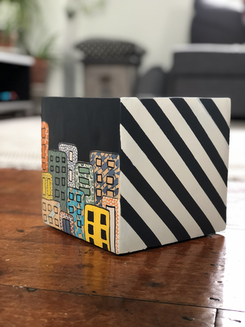 Painted squre plant pot with building and stripes