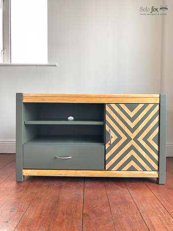 TV stand painted in sage green and stripe pattern