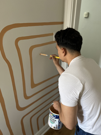 José paiting pattern in orange on a room wall
